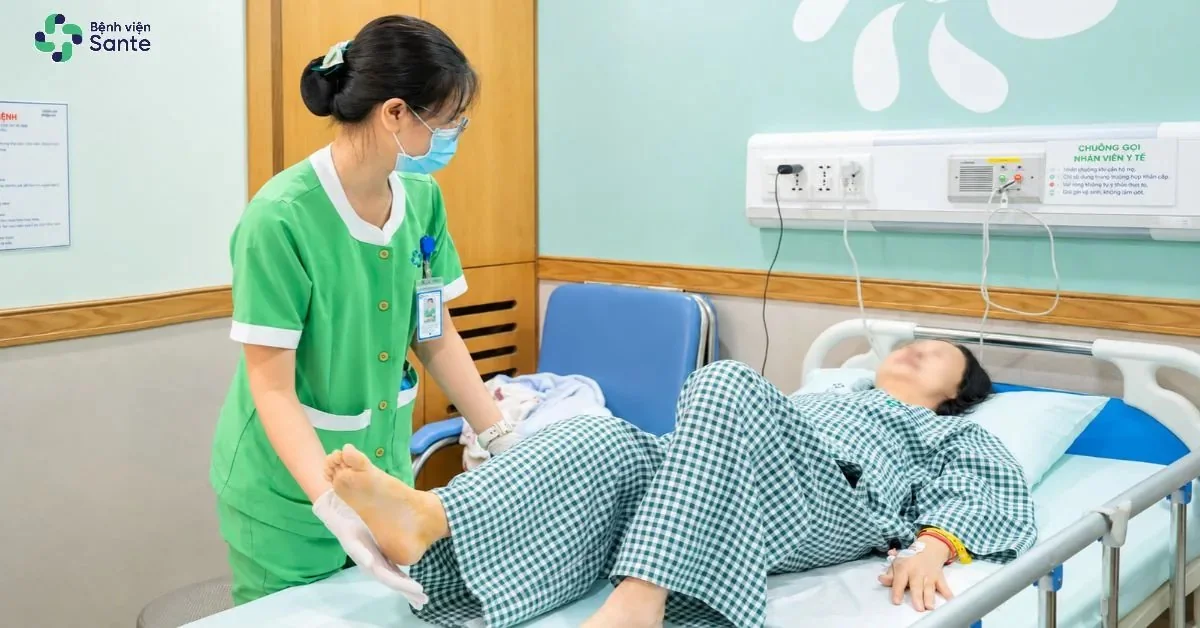 Kỹ thuật viên hướng dẫn người bệnh tập phục hồi chức năng sau mổ thay khớp gối